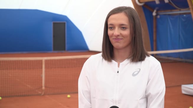 Profesjonalny tenisista w białej kurtce na korcie