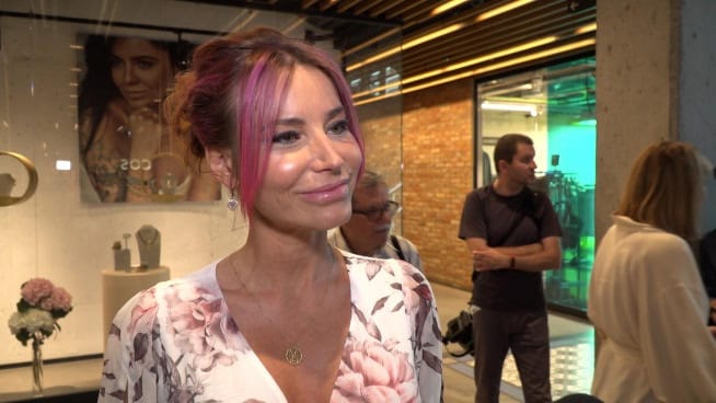 Kobieta z różowymi włosami na imprezie otwierającej sklep jubilerski