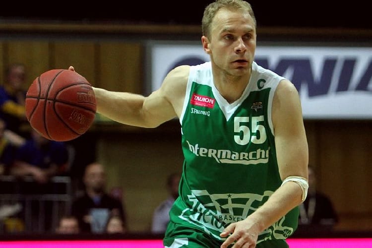 Koszykarz nr 55 drybluje piłkę podczas gry.