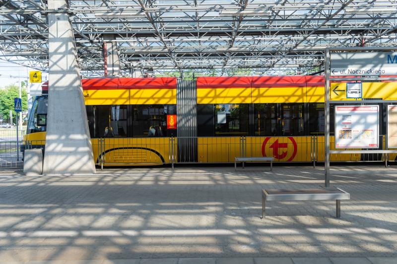 Nowoczesny żółty i czerwony tramwaj na peronie stacji miejskiej