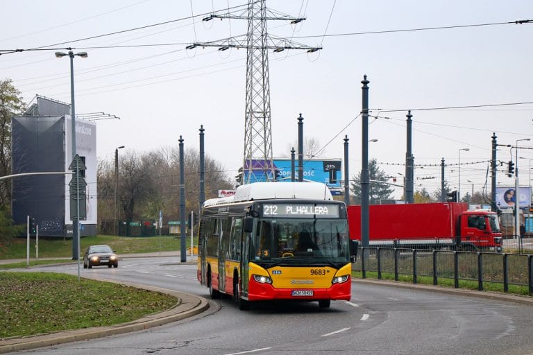 Żółto-czarny autobus miejski nr 9683 na linii 212 do Pl. Hallera jedzie ulicą miejską.