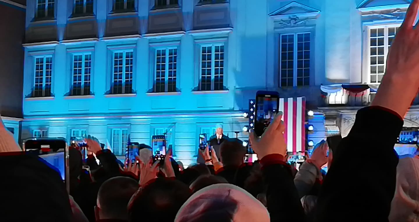 Tłum ludzi używa telefonów do nagrywania przemówienia Joe Bidena