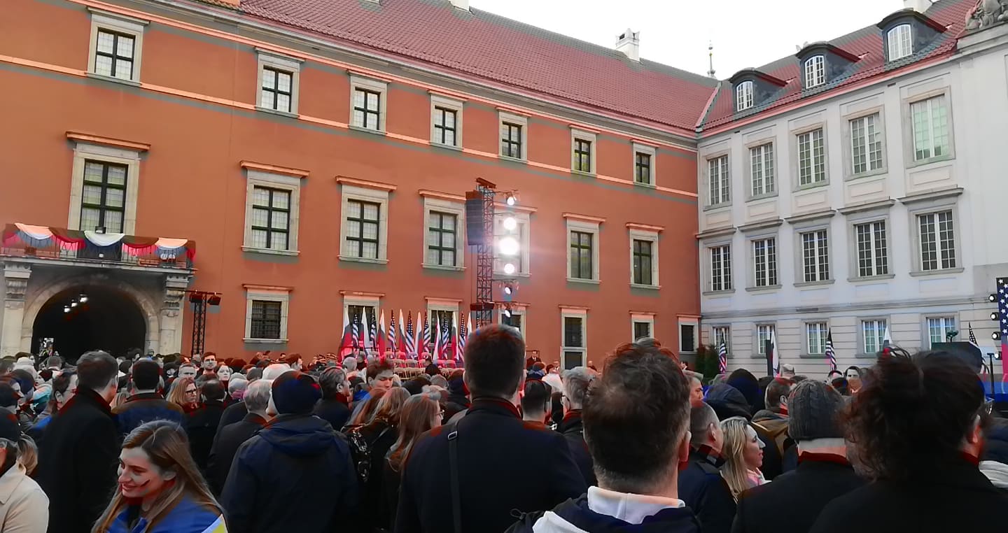 Tłum zbiera się na dziedzińcu Zamku Królewskiego w Warszawie podczas wizyty prezydenta Bidena, co jest wyrazem międzynarodowego poparcia.