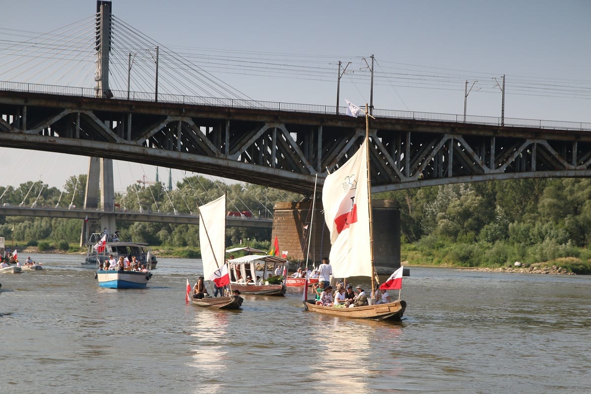 Tradycyjne polskie żaglówki na rzece pod mostem