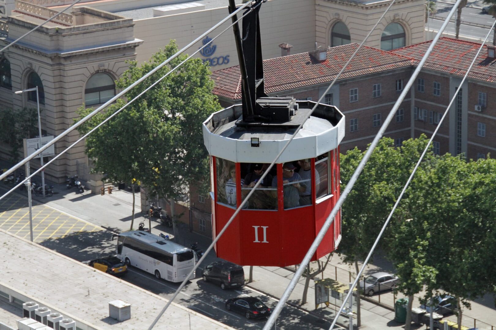 Czerwona kolejka linowa przewożąca pasażerów, widok z lotu ptaka, kolejka linowa na Montjuïc w Barcelonie.