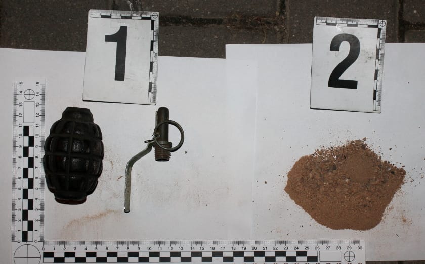 Dowody kryminalistyczne: granat, detonator i pozostałości materiału wybuchowego. Numery 1 i 2 oznaczają dowody.