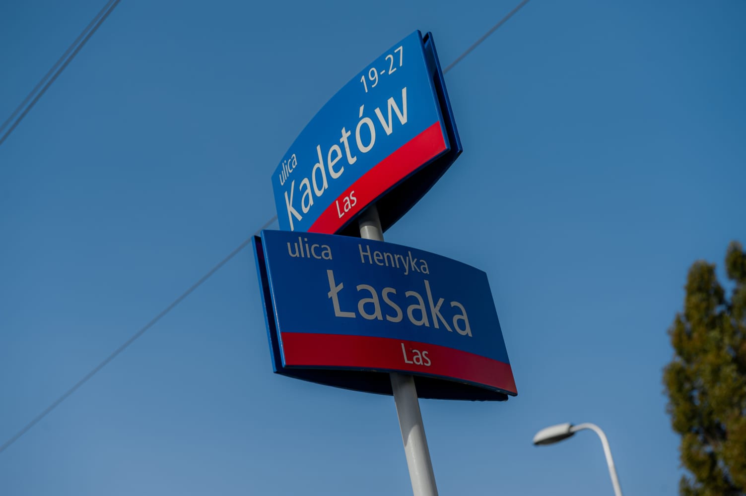 Znaki drogowe w Warszawie: ulica Kadetów i ulica Henryka Tasaka.