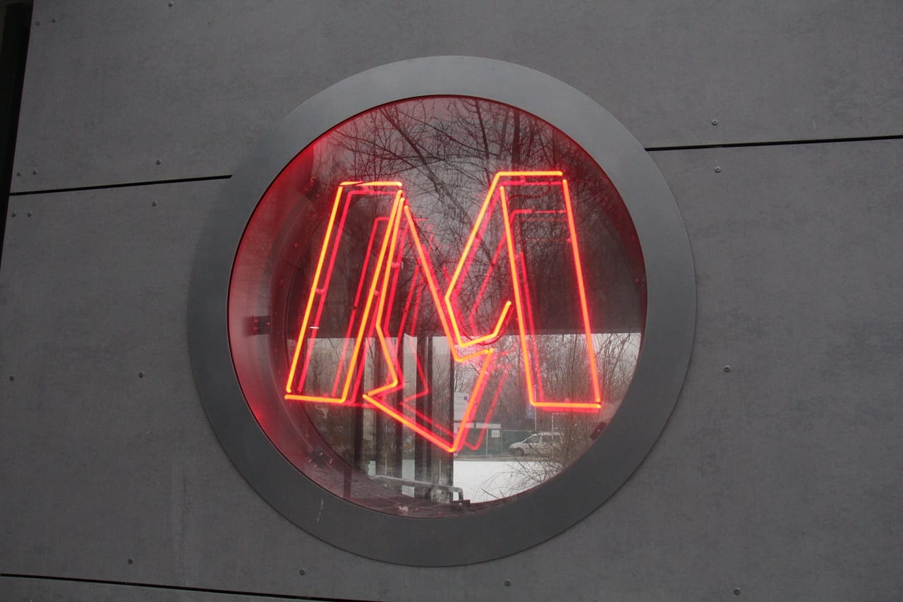 Czerwony neon z logo „M” w okrągłym oknie, metro moskiewskie