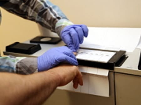 Zbliżenie na badanie krwi z nakłucia palca, pracownik służby zdrowia pomagający pacjentowi.