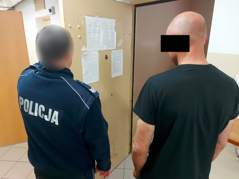 Policjant przegląda dokumenty podejrzanego.