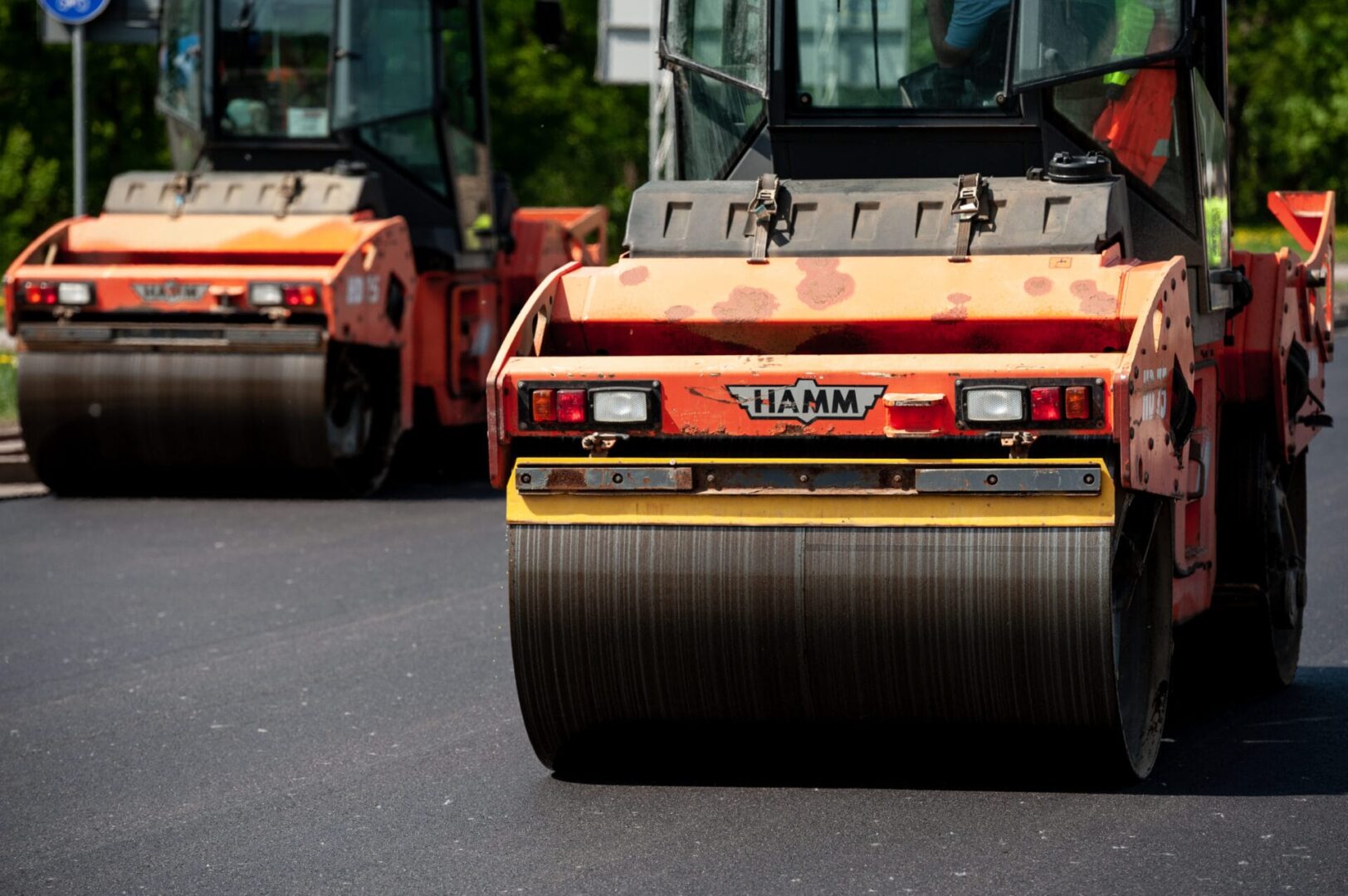 Dwa walce drogowe Hamm zagęszczające świeży asfalt.