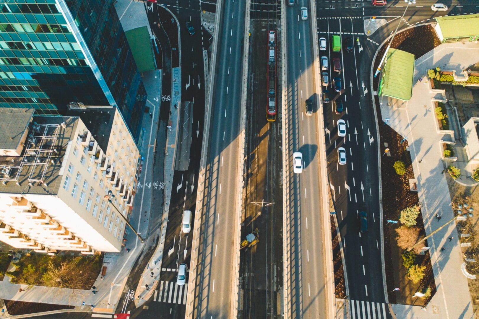 Widok z lotu ptaka na skrzyżowanie miasta z tramwajami i samochodami.