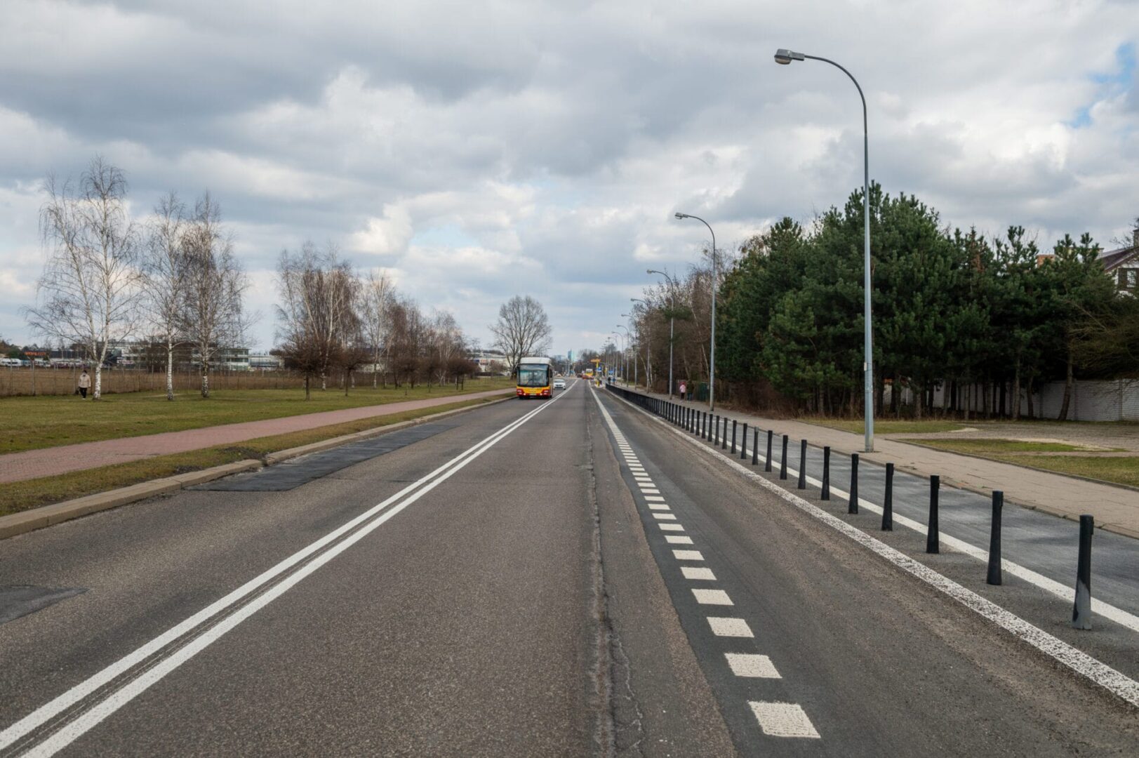 Pusta ulica miejska z autobusem i drzewami w pochmurny dzień