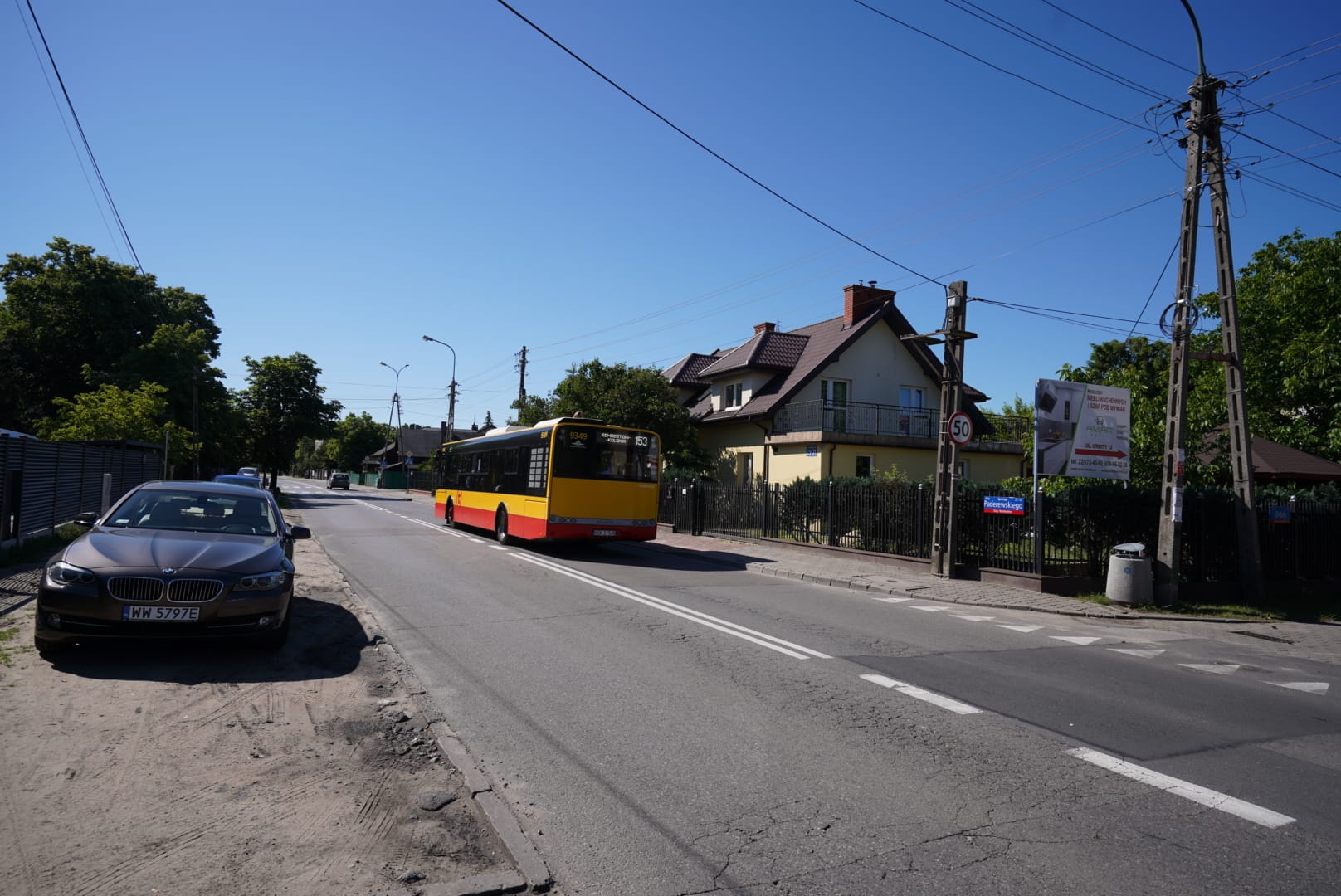Autobus na ulicy osiedlowej, zaparkowane BMW, ograniczenie prędkości do 50 km/h