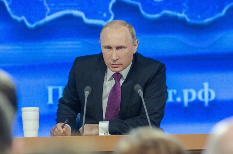 Władimir Putin na konferencji prasowej przemawia do mikrofonu.