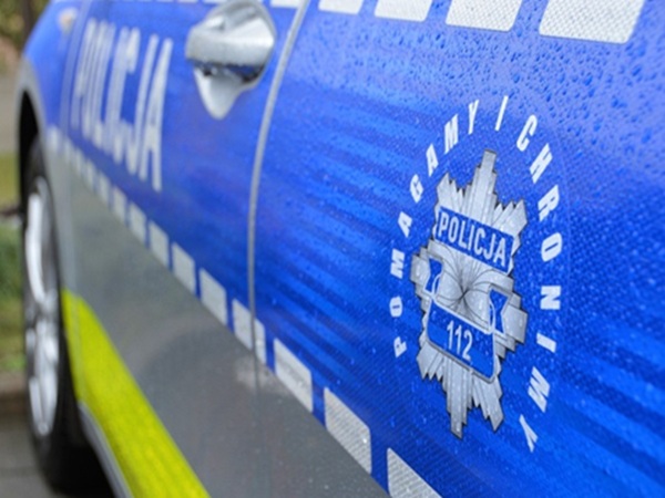 Zbliżenie na polski radiowóz, na którym widnieje emblemat „POLICJA” i numer alarmowy „112”.