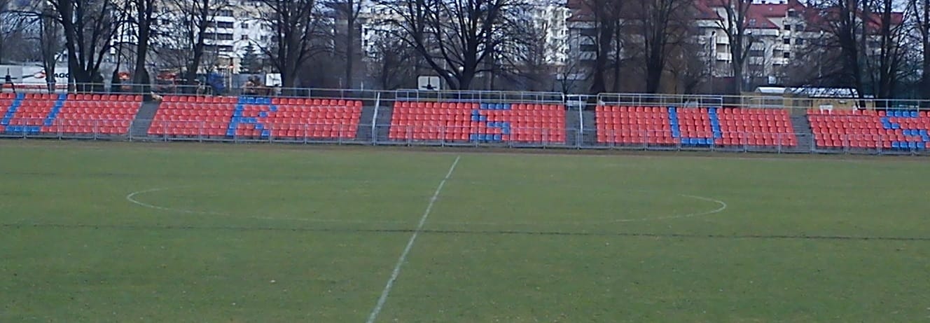 Puste siedzenia na stadionie piłkarskim z namalowanym napisem „RUS”.