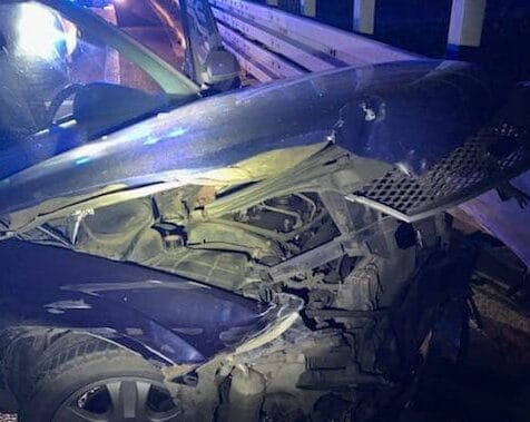 Samochód poważnie uszkodzony po kolizji, z widocznymi uszkodzeniami przodu.