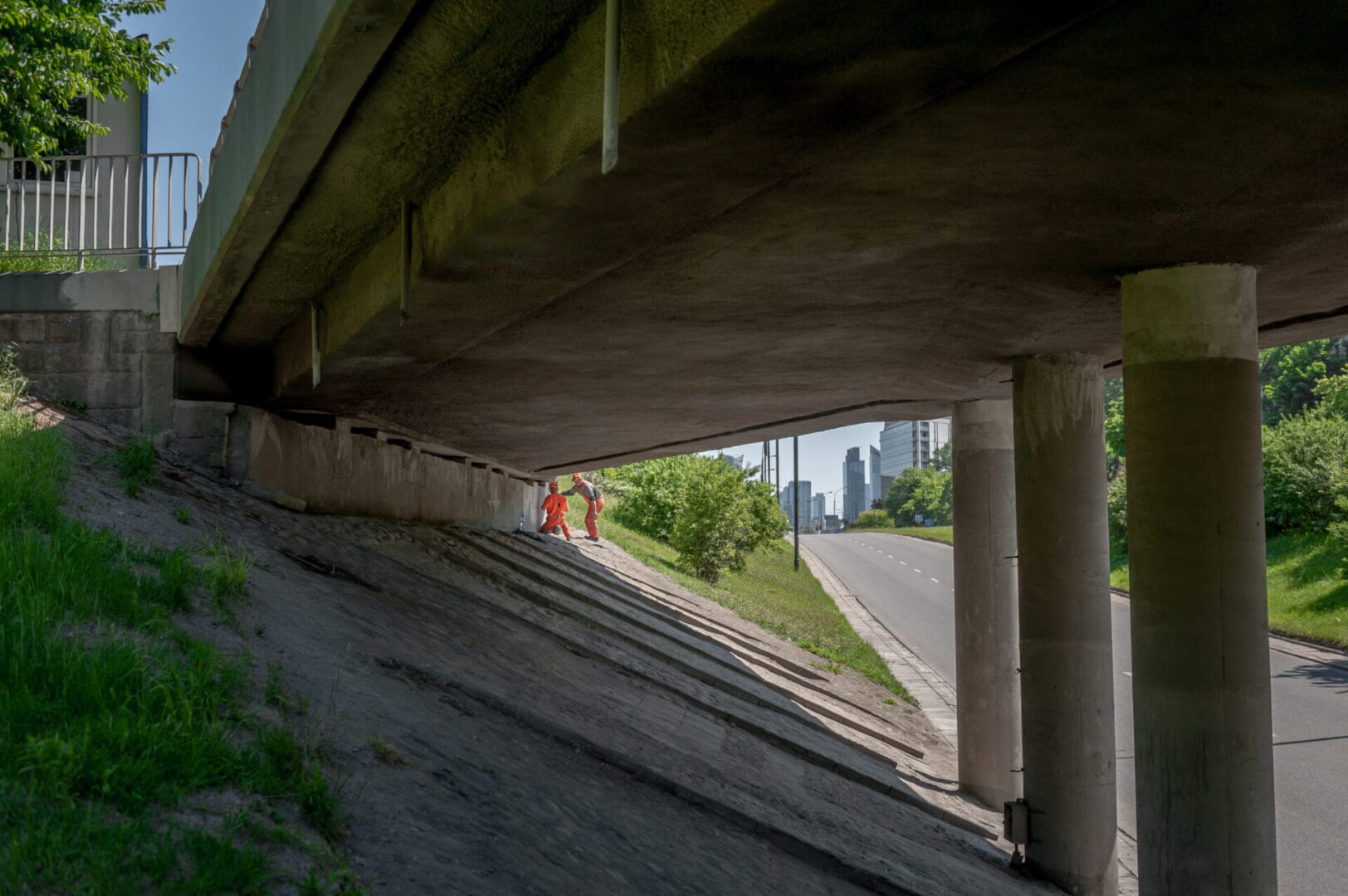 Robotnicy sprawdzają przejście pod mostem, widoczna droga